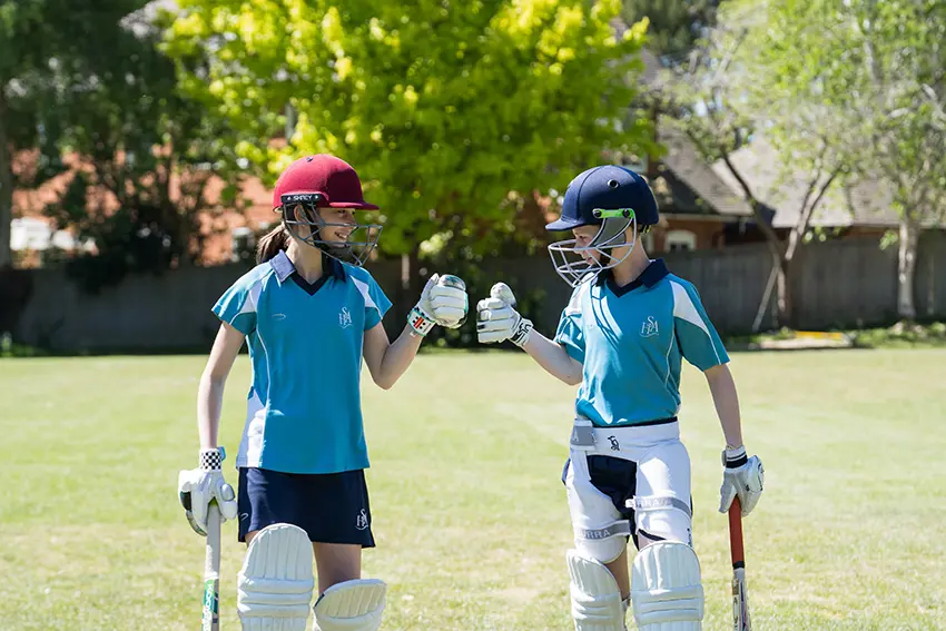 two girls in cricket in HSA sports kit 