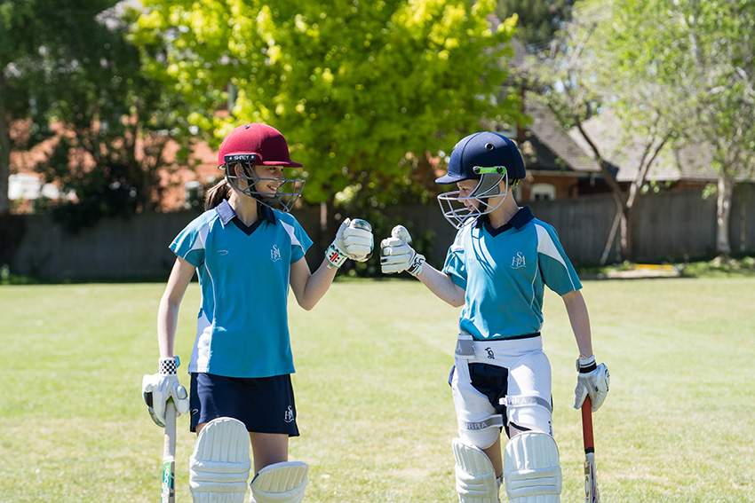 two girls in cricket gear 