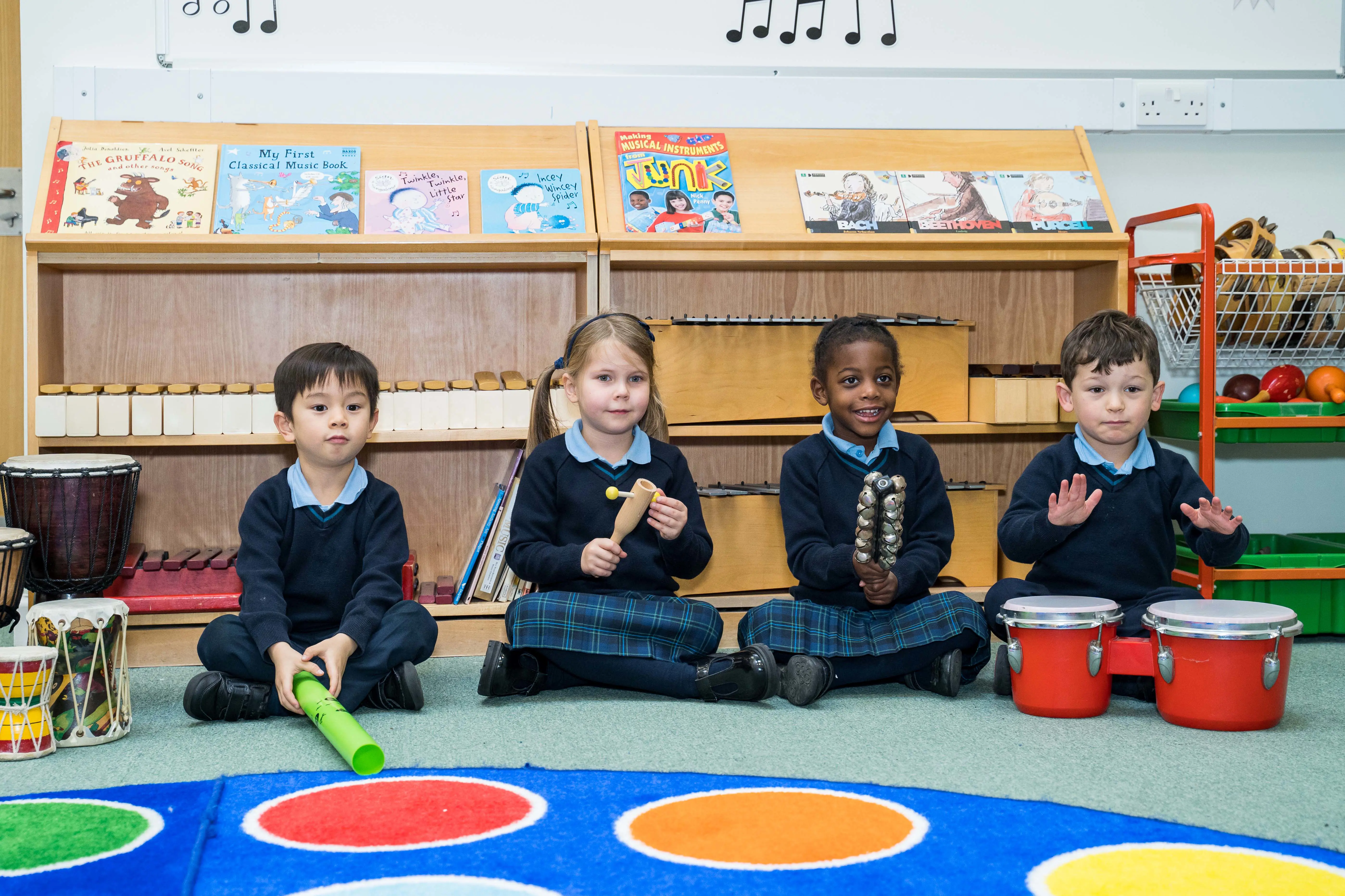 Four pupils playing instruments in the music room at Halstead St Andrew's School in Woking, Surrey