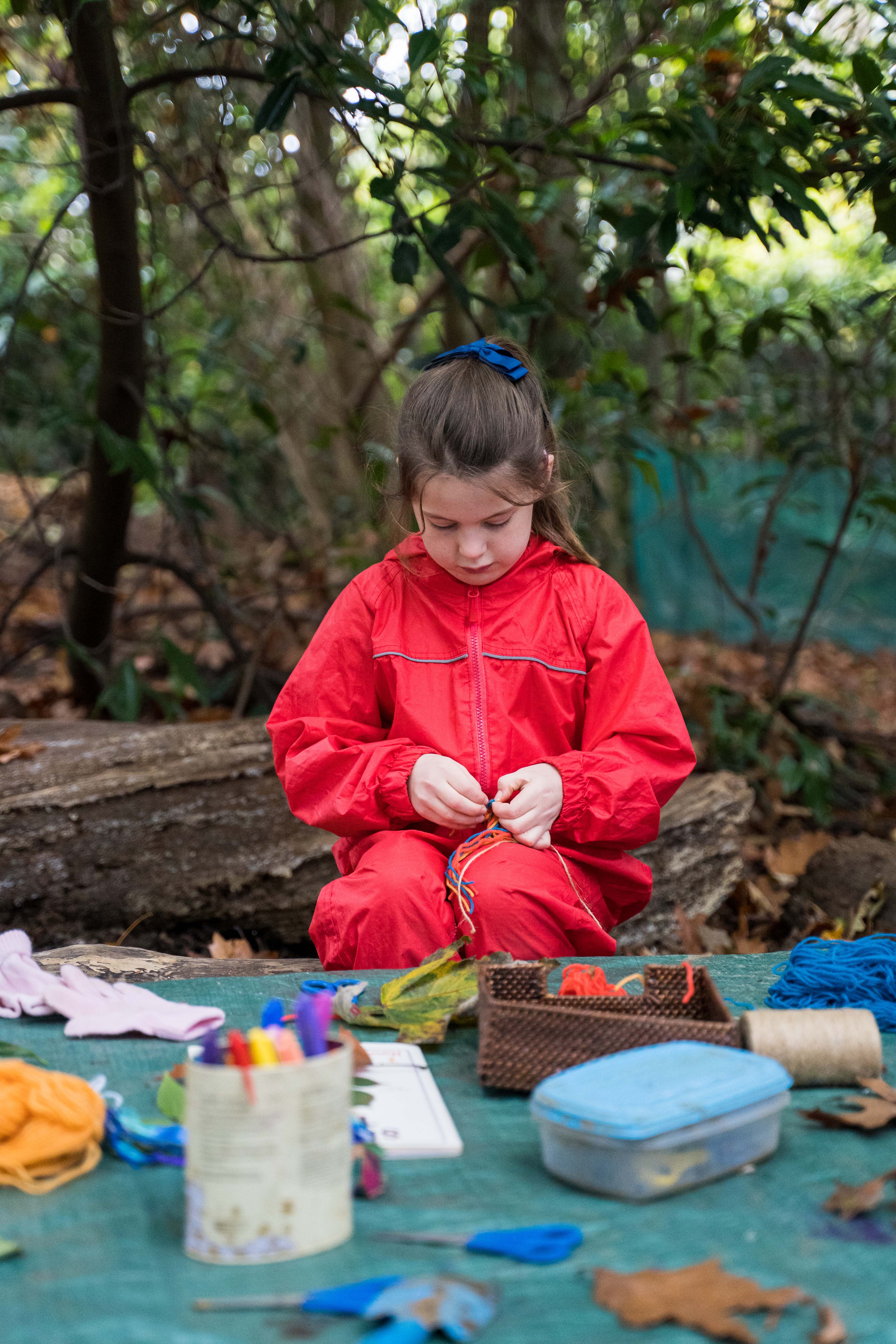 Girl in a red rain suit in an outdoor learning class