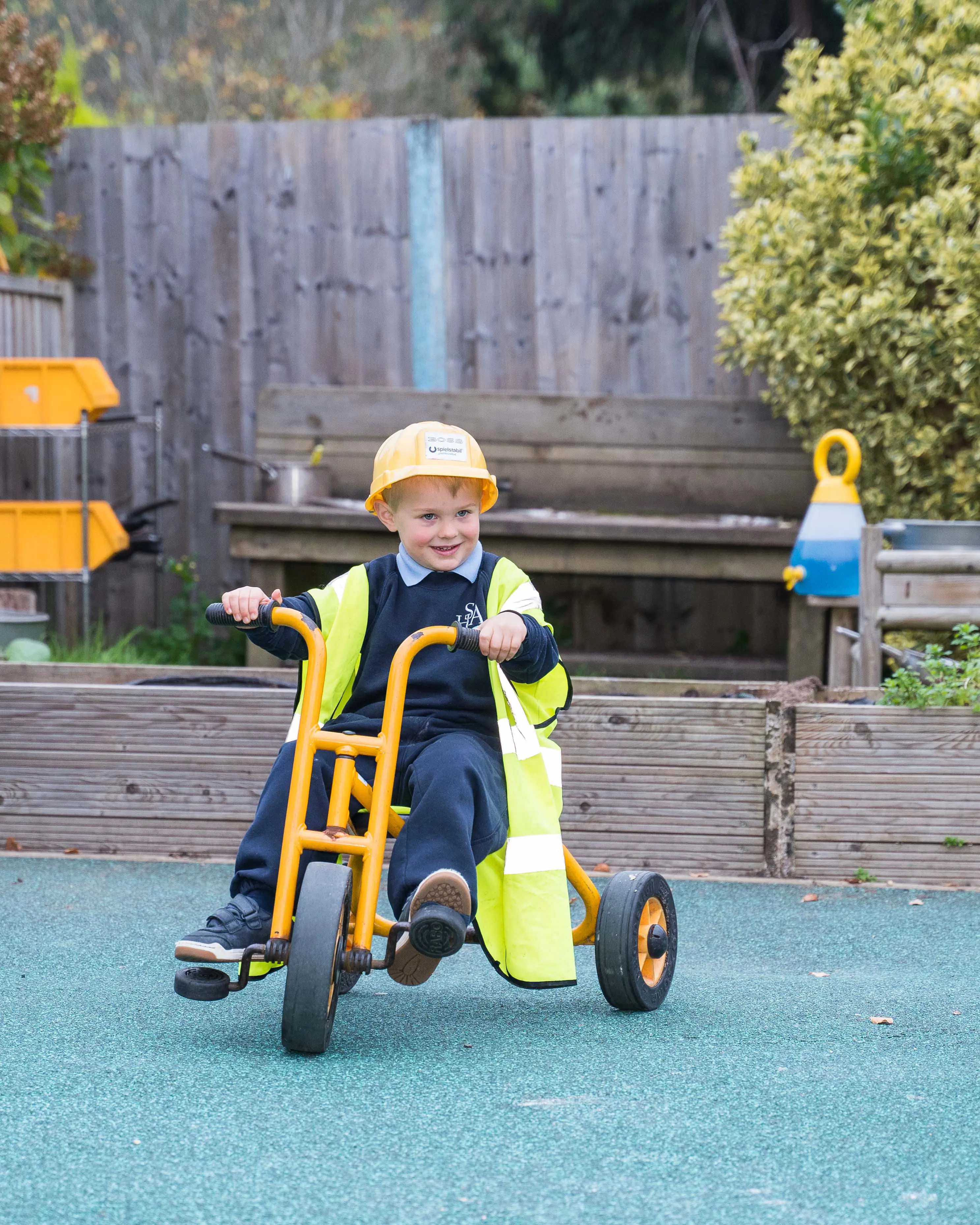 Pupil on a trike, playing in the playground at Halstead St Andrew's