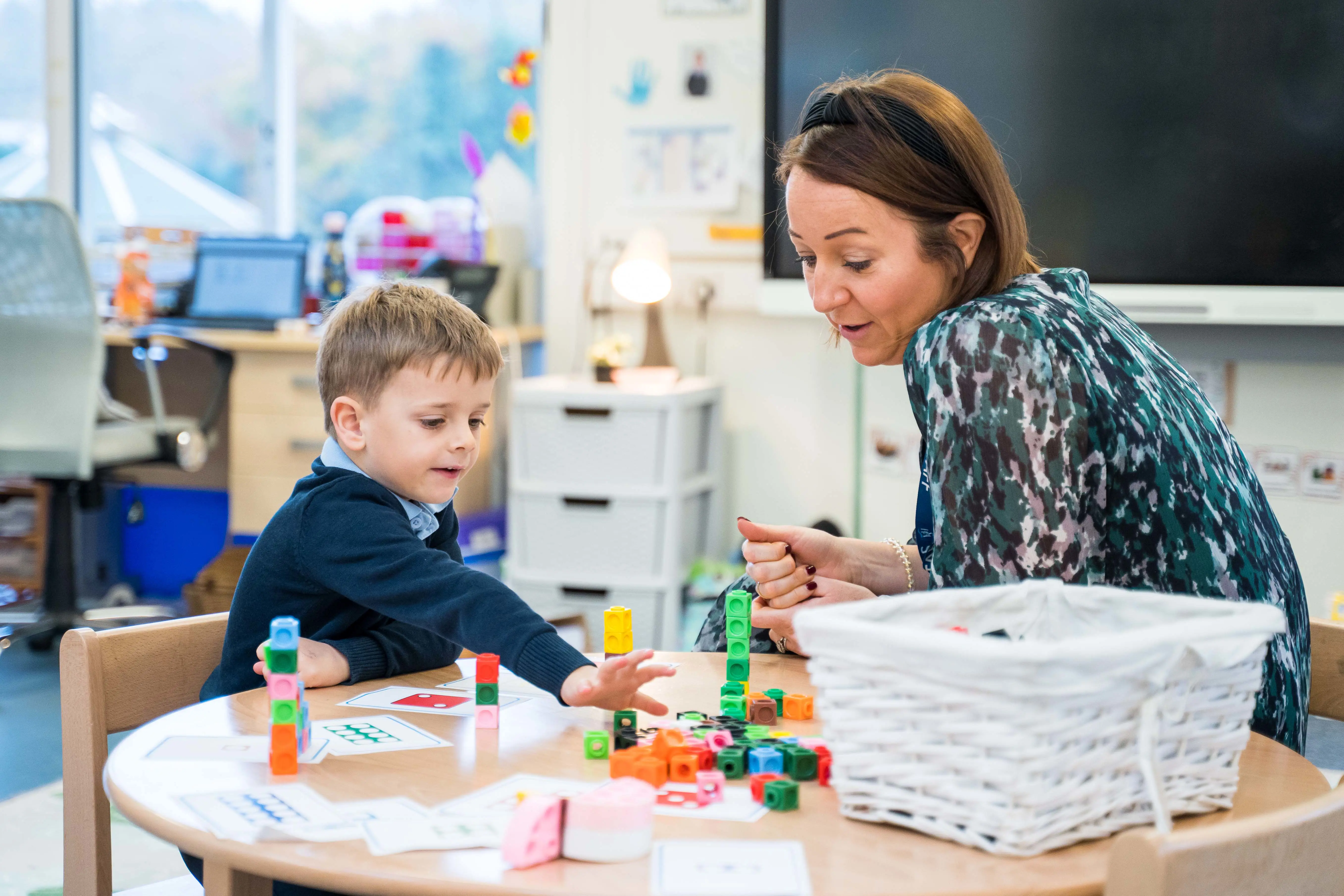 Pupil and teacher playing in sand pit in Pre-Prep at Halstead St Andrew's