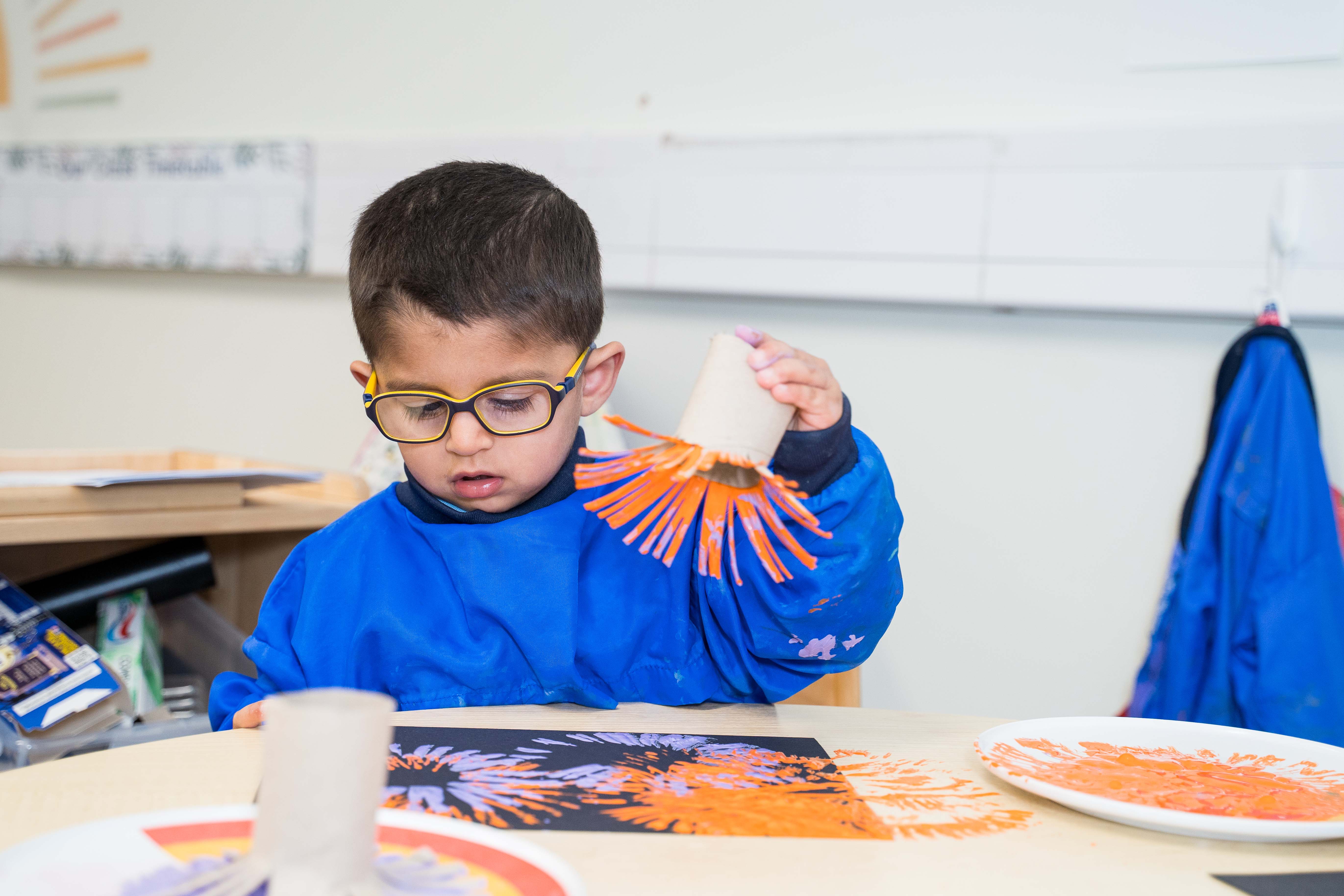 Boy playing with paint in Nursery