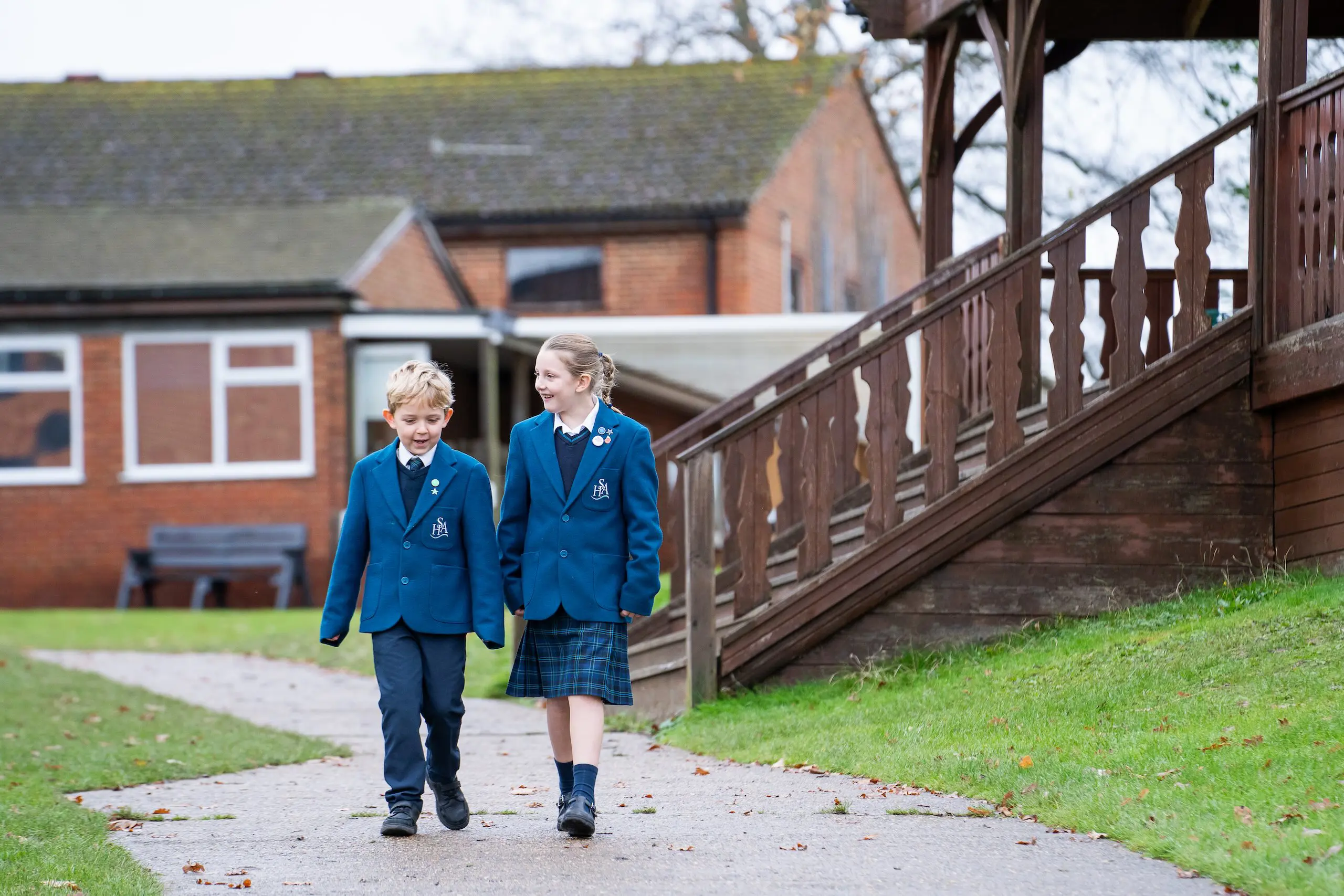 Two pupils walking through school grounds